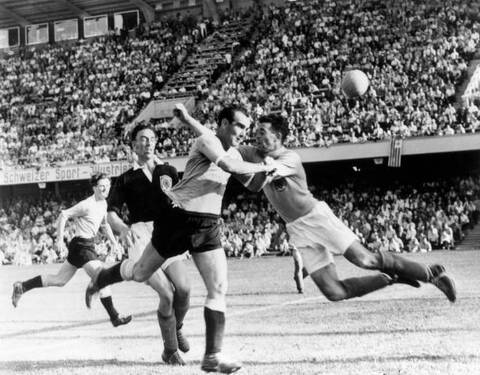 21st June 1954:  Scottish goalkeeper Martin rushes out as Uruguay's Miguez heads the ball over the bar, and Scotland's Davidson tries to intercept, during their World Cup match in Basel, Switzerland. Uruguay won the match 7-0.  (Photo by Edward Miller/Key